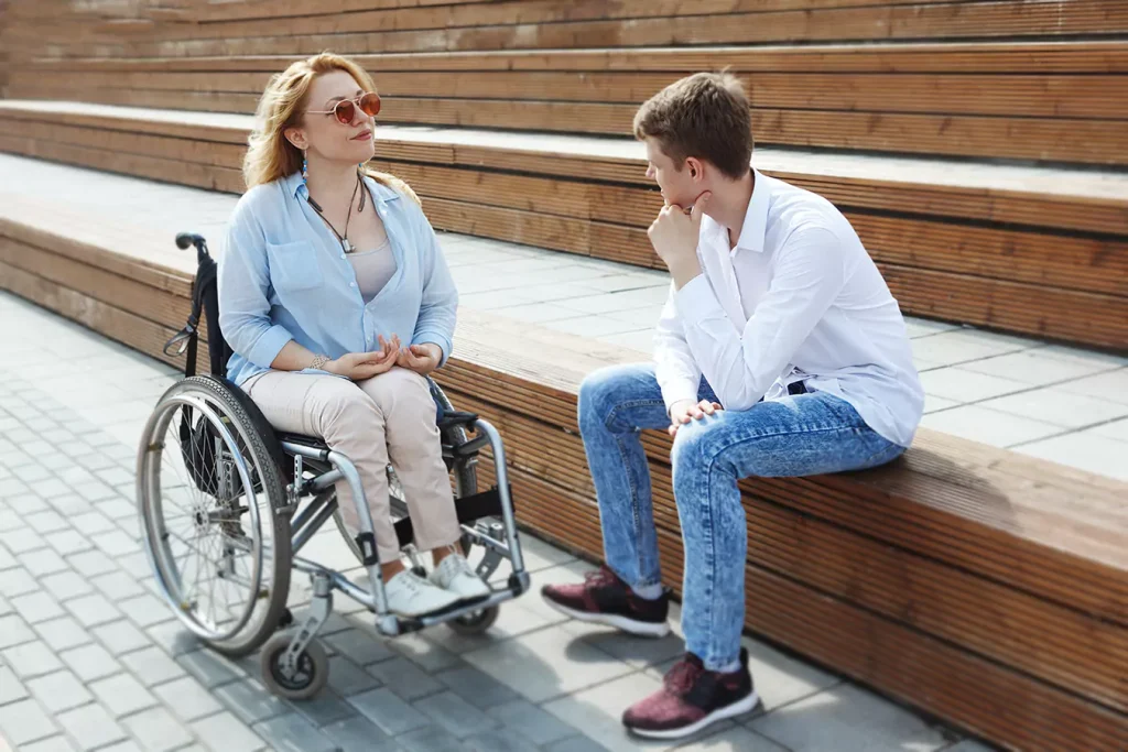 A disabled woman sitting in her wheelchair and her support worker